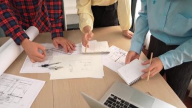 Mimarlık ve güvenlik mühendisi, modern ofiste doğruluk için mimari belge ve ölçüm aracı kullanılarak dizüstü bilgisayarın üzerinde sergilenen planlar hakkında tartıştı. - Yakın çekim. Tanımlama.