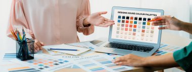 Yaratıcı grafik tasarımı seçici renkler sunarken, yönetici de masadaki uygun renkleri renk paletleriyle karşılaştırarak modern ofiste grafiksel malzeme dağılımı yapıyor. Değiştirilmiş.