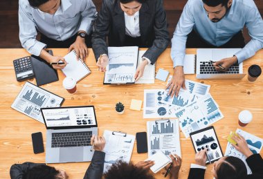 Üst düzey çok ırklı analiz ekibi toplantı masasındaki mali raporu analiz etmek için BI gösterge tablosu verilerini kullanıyor. Çeşitli iş adamlarından oluşan bir grup, iş kararı için FIntech 'in veri analizini kullanıyor. Uyum