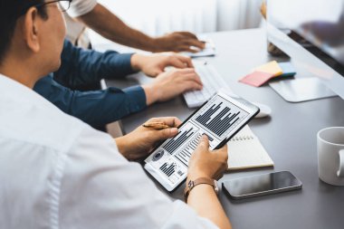 Veri analistleri ofis çalışanlarından oluşan bir ekip, tablet kullanarak finansal, trend ve pazarlama verilerini analiz etmek için iş istihbaratı BI gösterge paneli üzerinde işbirliği yapmaktadır. BI teknolojisi ve veri analizi kavramı. Tedbirli