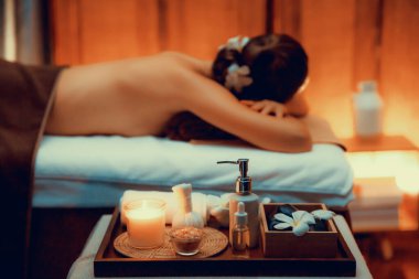 Aromaterapi masajı ambiyansı ya da spa salonu kompozisyon düzeneği bulanık kadınlara odaklı dekor mumları ve spa aksesuarları ile tatil köyü veya otel arka planında keyifli aroma spa masajı yapan. Sessiz.