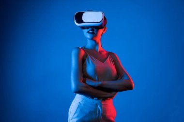 Akıllı kadın, metaevrene bağlı, fütürist siber uzay teknolojisine sahip VR kulaklık takıyor. Zarif kadın sanal alana bakarken kendine güvenerek poz veriyor. Halüsinasyon.