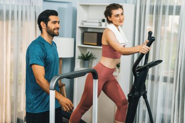 Atletik ve sportif genç çift ya da koşan makineyle koşan spor eşi, evde spor olarak vücut egzersizi yapmak. Gaiety evde egzersiz eğitimi.