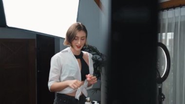 Arka plan etkileyicisi, vlog video gözden geçirme makyaj primi sosyal medya ya da blog kullanarak akıllı telefon yayınıyla canlı çekim yapıyor. İnternetteki pazarlama kaydı için kozmetik stüdyosu ışıklandırması olan kız.