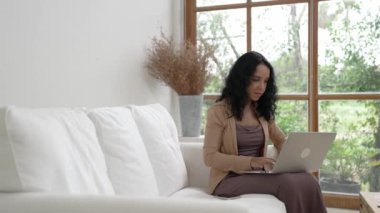 Telefonda konuşan Afro-Amerikalı bir kadın, internet üzerinde önemli bir iş için dizüstü bilgisayar kullanırken, aynı zamanda telesal yapıyor. Evde çalışan sekreter veya çevrimiçi içerik yazma.