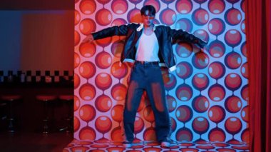 Asyalı break dansçı serbest stile geçiyor ve balon arka planlı kameraya bakıyor. Profesyonel hippi gündelik kıyafet giyer ve gözlük takar. Mutluluk.