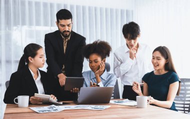 Çok ırklı analist ekibi toplantı masasındaki mali raporu analiz etmek için BI gösterge tablosunu kullanıyor. Çeşitli iş adamlarından oluşan bir grup, FIntech 'in veri analizini başarılı iş pazarlaması için kullanır. Uyum