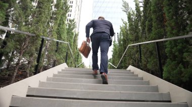 Kafkas işadamı merdivenlerden çıkıp akıllı telefon kullanarak müdürü arıyor. Yöneticinin pazarlama ekibinden bahsedişinin ve merdivenleri çıkarken telefonla finansal strateji planlamasının arka planında. Urbane.