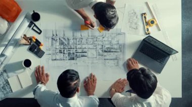 Mühendis ekibiyle tasarım planlarken iç mimar yazımının yukarıdan aşağı görüntüsü yapışkan notta. Çeşitli mimarlar ve usta yöneticilerden oluşan bir grup bina inşaatı arıyor. Hizalama.