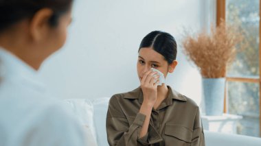 Psikologla ruh sağlığı terapisi gören üzgün travma sonrası stres bozukluğu olan bir kadın. Yaşam sonrası depresyon veya keder. Hayal kırıklığına uğramış genç bir kadın klinikteki duygular hakkında Vivancy psikoloğuyla konuşuyor.