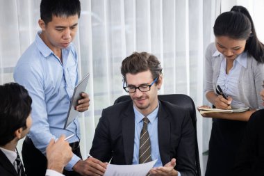 Modern ofis ortamında çalışan çeşitli etnik gruplardan çeşitli iş adamları. Üretken ve çok ırklı ofis çalışanları stratejik ticari pazarlama konusunda tartışmaya giriştiler. Çok titiz.