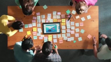 Tablet kablo prototipine bakarken, web tasarımı hakkında beyin fırtınası yapan ve planlayan programcıların tepeden tırnağa görüntüsü. Yetenekli müteahhit takımının dijital uygulamadan bahseden hava görüşü. Sempozyum.