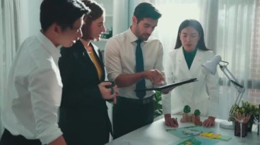 Profesyonel akıllı iş adamları, temiz enerji ve sürdürülebilir yatırımı rüzgar değirmeniyle toplantı masasında kullanma, çevre grafiği ve ahşap ev modeli ile belgelendirme konusunda tartışıyorlar. Hizalama.