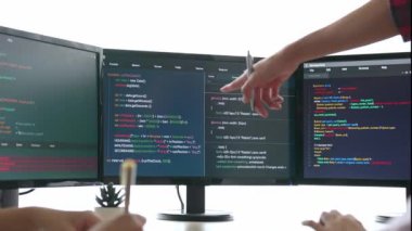 Yavaş çekim arkası yazılım geliştirici mühendisi bilgisayar programlama için birlikte çalışarak hata ayıklama kodunu çözüyor, ofiste monitörde karmaşık algoritmaları çözüyor. Filizlenen