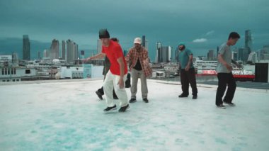 İspanyol hipster dansları şehrin mavi gökyüzü manzaralı çok kültürlü arkadaşlarıyla çevrili. Çatıda bir grup sokak dansçısı sahne alıyor. Aktif, eğlenceli, mutlu atmosfer. Açık hava sporu 2024 hiphop..