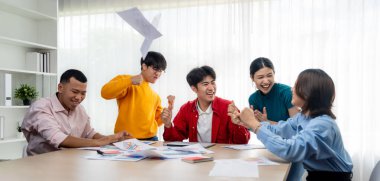 Heyecanlı ve mutlu bir şirket çalışanı başarılı bir iş yaptıktan sonra kutlama yapıp havaya kağıt fırlatıyor. Takım çalışması ve pozitif çevre üretken ve destekleyici bir işyeri yaratır. Sinerjik