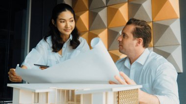 Mimar mühendis takım tasarımı portresi ve proje planı kullanarak ev hakkında tartışmak. Proje yöneticisi, ev inşaatını mimari modeli masaya yerleştirilmiş mühendislere açıklıyor. Yönlendirici.