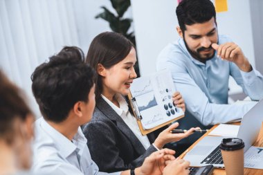 Çok ırklı analist ekibi toplantı masasındaki mali raporu analiz etmek için BI gösterge tablosunu kullanıyor. Çeşitli iş adamlarından oluşan bir grup, FIntech 'in veri analizini başarılı iş pazarlaması için kullanır. Uyum