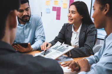 Çok ırklı analist ekibi toplantı masasındaki mali raporu analiz etmek için BI gösterge tablosunu kullanıyor. Çeşitli iş adamlarından oluşan bir grup, iş pazarlama kararı için FIntech 'in veri analizini kullanır. Uyum