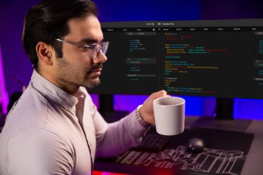 Akıllı IT geliştiricisi bilgisayar ekranında yazılım geliştirme kodlamasında çalışırken kahve fincanı içiyor, neon ışıklandırma siber ofisinde program uygulama güncelleme veritabanı sunuyor. Tahmin et..