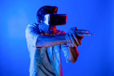 Kafkasyalı zeki bir adam VR gözlük takıyor ve hareket eden bir jest silahı taşıyor. Oyuncu, gelecekteki sanal gerçeklik kulaklığını ya da gelecekteki yenilikleri kullanarak meta dünyaya giriyor ya da aksiyon oyunu oynuyor. Sapma.