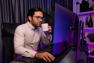 Akıllı profesyonel işadamı, iş veri analiziyle birlikte neon ışıklı siber ofis işyerinde kahve içerek ürün raporundaki araştırma hedef pazarına odaklanıyor. Tahmin et..