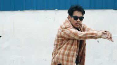 İspanyol komedi koreografı hip hop tarzında dans ediyor. Genç mutlu break dansçı B-boy dansı yapıyor. Sokak dansı yapan komik adamın hareket çekimi. Açık hava sporu 2024. Modern dans. hiphop.