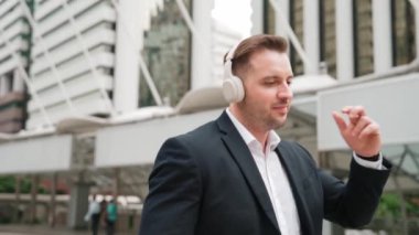 Mutlu iş adamı kulaklık takıyor, müzik dinliyor ve şehir merkezinde canlı bir şekilde yürürken müzik eşliğinde hareket ediyor. Menajer kulaklık takar ve gevşetici kafiyelerin keyfini çıkarır. Urbane.