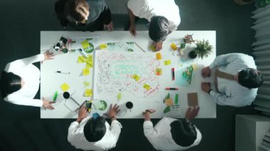 Profesyonel iş adamlarının zihin haritasını kullanarak beyin fırtınası yapmak için birlikte çalıştıklarına dair üst düzey bir görüş. Akıllı yöneticilerin sürdürülebilir enerji hakkında konuştuğu ve tartıştığı hava görüntüsü. Hizalama.