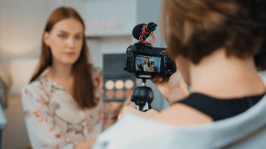 Etkilenen iki ortak canlı yayında video görüntülerini çekiyor makyaj malzemesi prim sosyal medya veya blog. Kozmetik stüdyosu ışıklandırmalı mutlu genç kız çevrimiçi pazarlama oturumu yayını için..