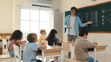 Öğrenci ödevlerine bakarken sınıfta yürüyen yetenekli bir öğretmen. Sınav yaparken ya da sınıfta ödev yaparken akıllı çocuk defterini kontrol eden profesyonel bir eğitmen. Pedagoji.