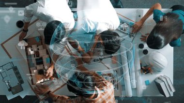 Yetenekli mimar mühendisinin birlikte çalışması ve küresel bağlantı hologramıyla kooperatif ekibe fikir vermesi. Yöneticinin dikilip plandan bahsedişinin havadan görüntüsü. Hizalama.