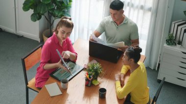 Proje yöneticisi renk paletleri seçerken tasarımcının tablete baktığı yukarıdan aşağıya hava görüntüsü. Yetenekli grafik tasarımının zaman aşımı ve logoya bak. Yetenekli ekip grafikleri seçiyor. Sempozyum.