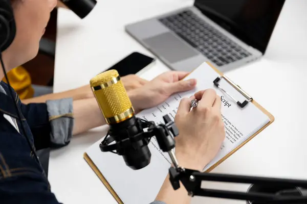 stock image Selective focusing on hands with writing script note of radio influencer host with microphone on channel social media online live streaming on blurry background at morning at studio record. Infobahn.