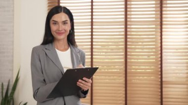 Mutlu ve gülümseyen kadın psikolog psikiyatri ofisinde ya da terapi odasında pano tutuyor. Arkadaş canlısı ve profesyonel ruh sağlığı danışmanı ya da terapisti. Blithe