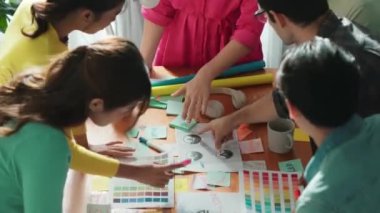 İşletme ekibinin üst görüntüsü toplantı masasına renkli yapışkan notlar ve tasarım ile grafik logo yazarak fikri açıklar. Proje yöneticisi fikri paylaşıyor ve akıllı takıma konsept sanatı anlatıyor. Sempozyum.