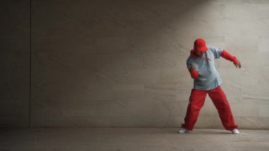 Profesyonel Asyalı hipster gri arka planlı break dansçı performansı sergiledi. Çekici bir sokak dansçısı şık kıyafetler giyerken hareketli hareketler yapar. Açık hava sporu 2024. Uzayı kopyala Yumuşak bir şekilde..