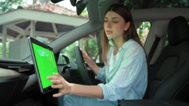 Çevre dostu araba konseptiyle tatil gezisi. EV batarya durumu için boş telif alanı yeşil ekran arabaları tutan sürücü koltuğundaki çevre bilinci olan genç çift. Yükselt
