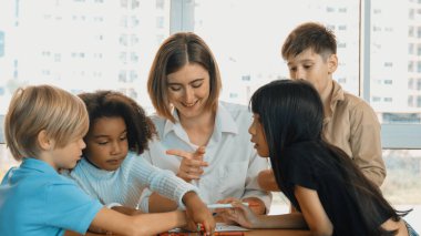 Masada masal kitabı ve renkli kitapla otururken çeşitli öğrencilere hikaye anlatan profesyonel beyaz bir öğretmen. Eğitmenden renkli resim alırken akıllı öğrenci dinlemeyi öğrenir. Etkinlik.