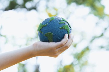 Dünya gezegenini ESG ilkesi ve çevre dostu enerjisiyle daha parlak bir gelecek için Dünya günü olarak el ele tutuşan genç çocuklar. Döngü