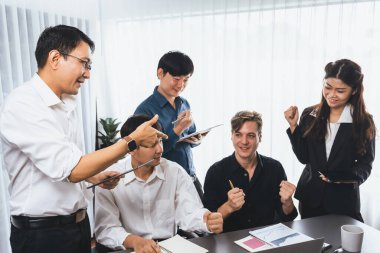 Heyecanlı ve mutlu bir ofis çalışanı başarılı bir stratejik iş pazarlama planlaması yaptıktan sonra kutlama yapıyor. Takım çalışması ve olumlu tutum verimli ve destekleyici bir iş yeri yaratır. Tedbirli