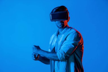 Kafkasyalı bir adam VR cam takıyor ve hareket eden el kol kılıcını tutuyor. Oyuncu, gelecekteki sanal gerçeklik kulaklığını ya da gelecekteki yenilikleri kullanarak meta dünyaya giriyor ya da aksiyon oyunu oynuyor. Sapma.