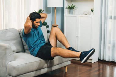Atletik vücut ve aktif sporcu, sağlıklı vücut çalışma yaşam tarzı konsepti olarak neşeli ev egzersizlerinde kas kazanma egzersizi yapmak için mobilyaları kullanıyor..