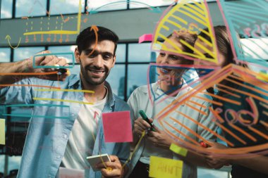 İş arkadaşı plan yaparken cam duvarı işaret eden yetenekli bir proje yöneticisi. Çeşitli iş adamları birlikte çalışıyor, pazarlama fikri ya da iş planı üzerinde kafa yoruyorlar. Yaratıcı bir başlangıç. İzleme.