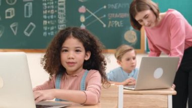 Çekici kız kodlama hızlı BTMM sınıfında kameraya bakarken mutlu öğretmen akıllı çocuk yazılım programını kontrol ediyor. Programlama kodu ve bilgisayar sistemi üzerine çeşitli öğrenci çalışmaları. Pedagoji.
