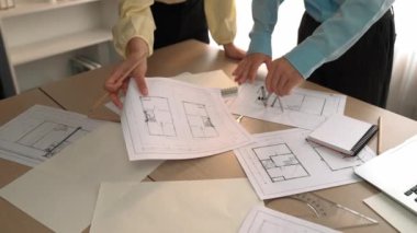Mimarlık ve güvenlik mühendisi, modern ofiste dizüstü bilgisayarda mimari belge ve ahşap blokla sergilenen planlar hakkında tartıştı. - Yakın çekim. Tanımlama.
