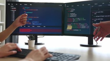 Yavaş çekim arkası yazılım geliştirici mühendisi bilgisayar programlama için birlikte çalışarak hata ayıklama kodunu çözüyor, ofiste monitörde karmaşık algoritmaları çözüyor. Filizlenen