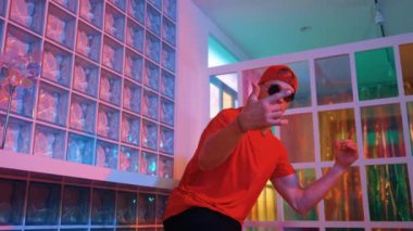 Komik break dansçı kameraya bakarken hiphop 'a doğru serbest adım atıyor. Çılgın mutlu hipster dans edip sokak dansı yaparken Led ışığında günlük kıyafet ve güneş gözlüğü takıyor. Mutluluk.