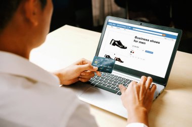 Genç adam, laptop bilgisayar başvurusu ya da web sitesinde online alışveriş yapmak için kredi kartı kullanıyor. E-ticaret ve online alışveriş konsepti. uds