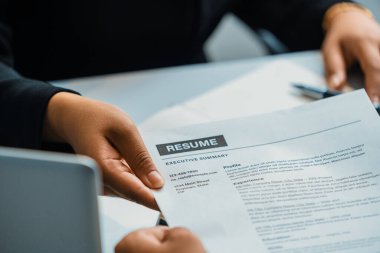 Çalışan adayın yakın görüntüsü CV 'yi röportaj yapan insan kaynakları müdürüne teslim eder. İş başvurusu, işe alım ve işçi alma konsepti. uds